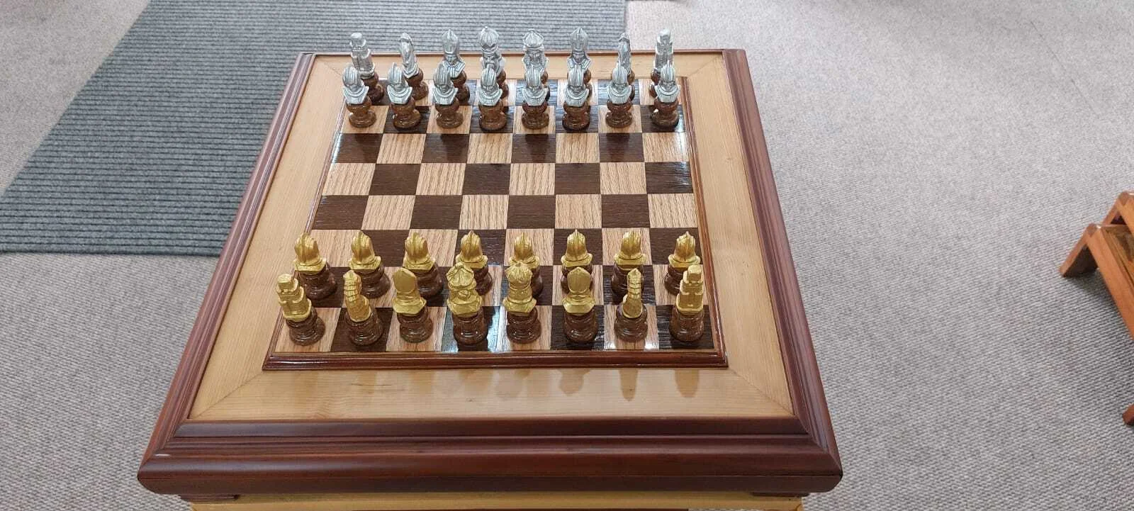 Premium handcrafted wooden chess table with metallic gold and silver pieces, showcasing open storage drawers with green felt lining.