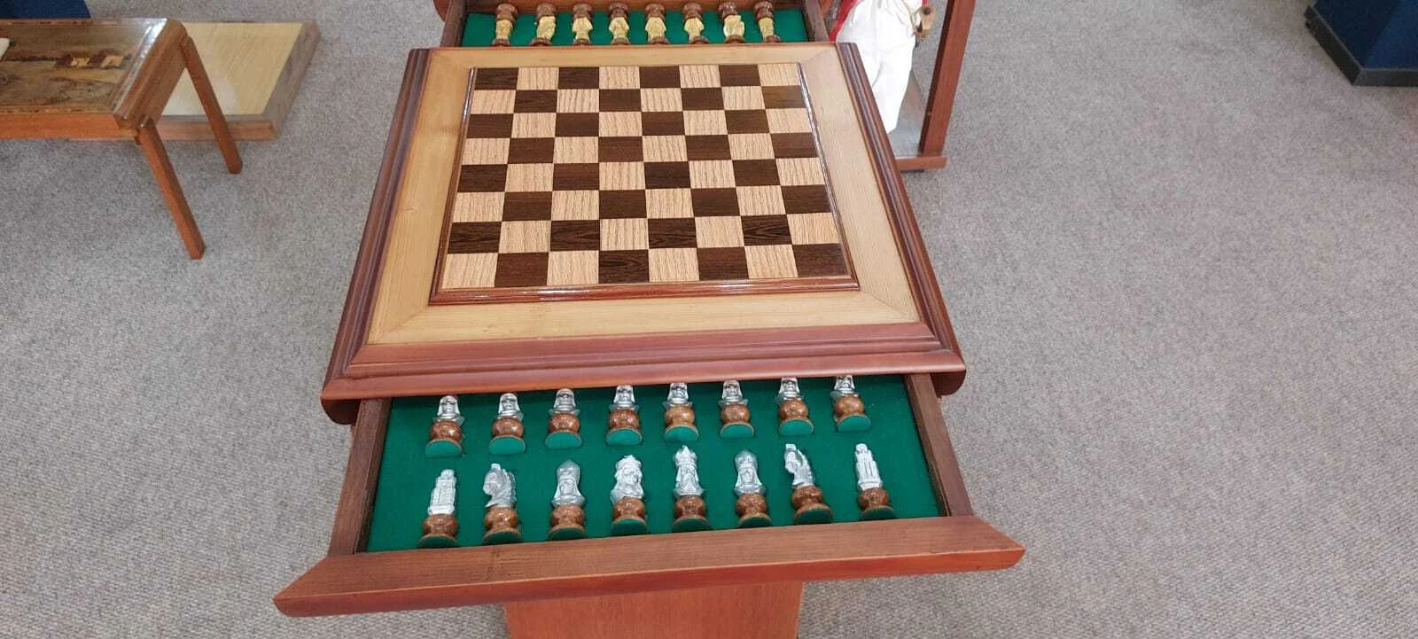 Premium handcrafted wooden chess table with metallic gold and silver pieces, showcasing open storage drawers with green felt lining.