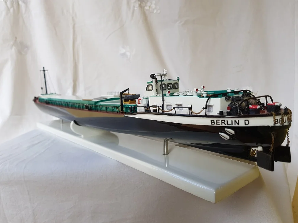 High-end handcrafted wooden sailboat model of the Blueprint Brussow on a minimalist presentation stand.
