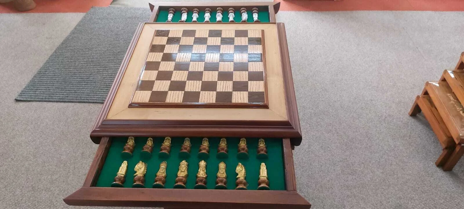 Premium handcrafted wooden chess table with metallic gold and silver pieces, showcasing open storage drawers with green felt lining.