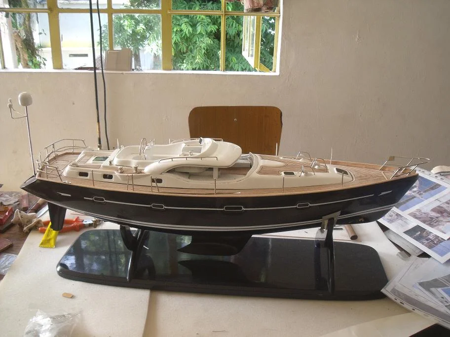 Handcrafted wooden model ship of the Macado sailing cruiser with fully deployed sails and detailed deck rigging.