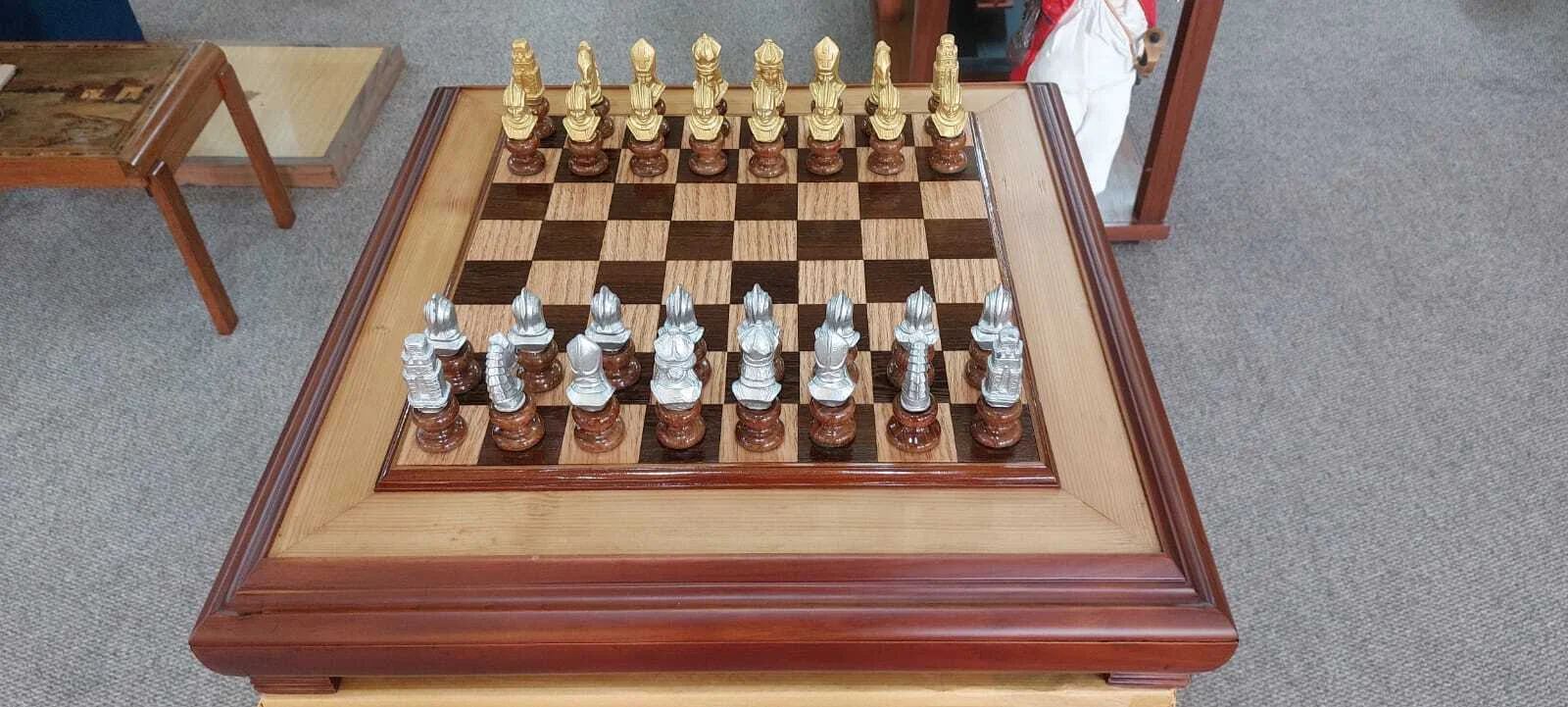 Premium handcrafted wooden chess table with metallic gold and silver pieces, showcasing open storage drawers with green felt lining.