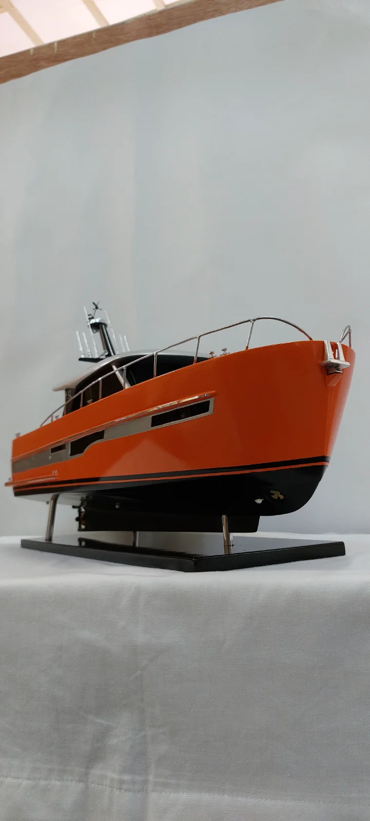 High-end custom handcrafted wooden scale model of the Yanos Diva luxury powerboat on a minimalist display stand.