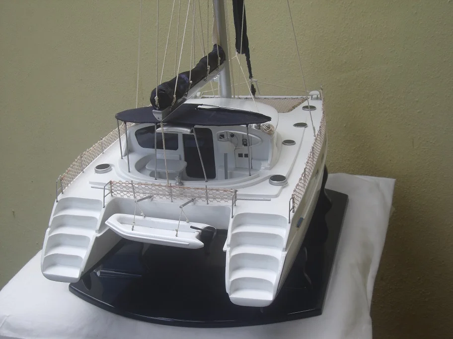 Handcrafted scale wooden model of the Belize 43 sailing catamaran with full fabric rigging on a premium display base.