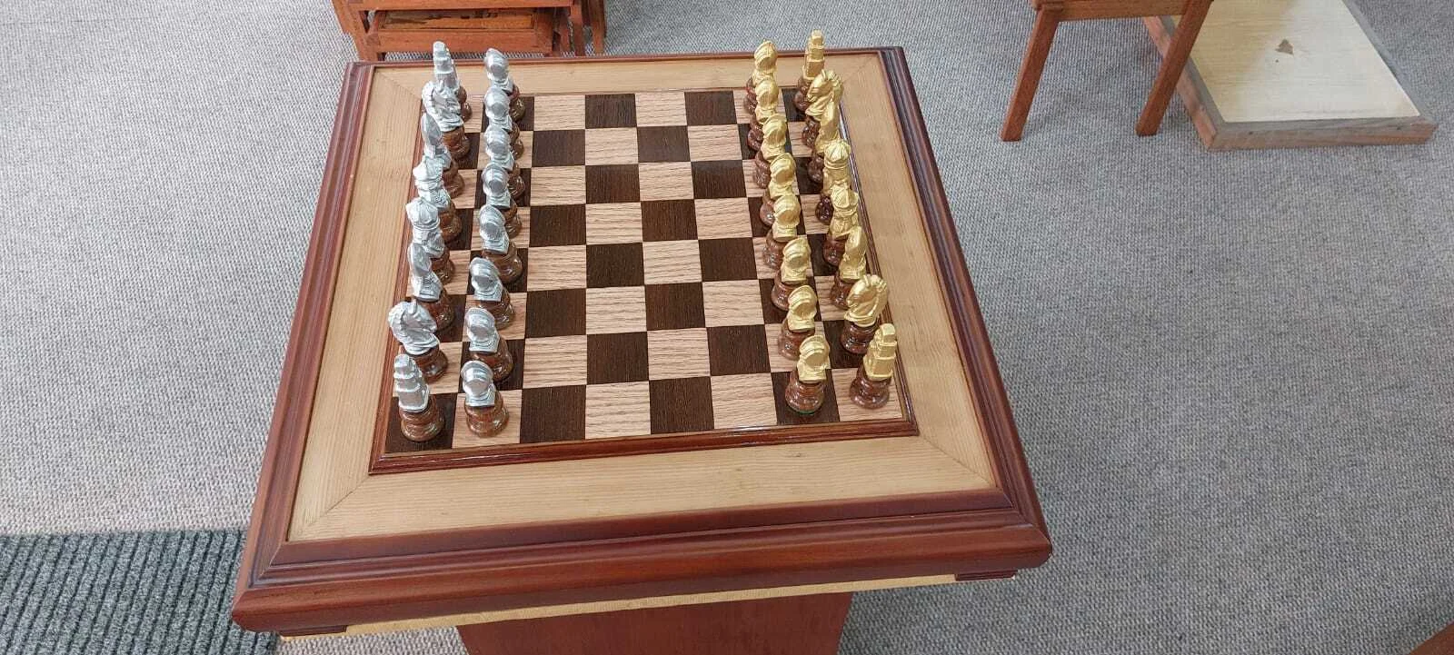 Premium handcrafted wooden chess table with metallic gold and silver pieces, showcasing open storage drawers with green felt lining.