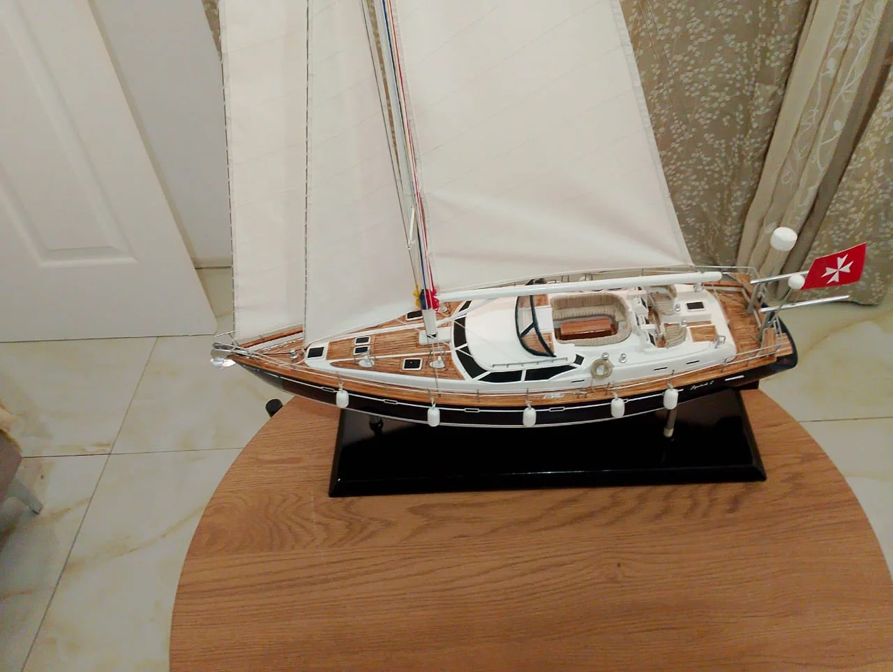 Handcrafted premium wooden scale model of the modern Delphia 29 sailing cruiser with full rigging on a luxury stand.
