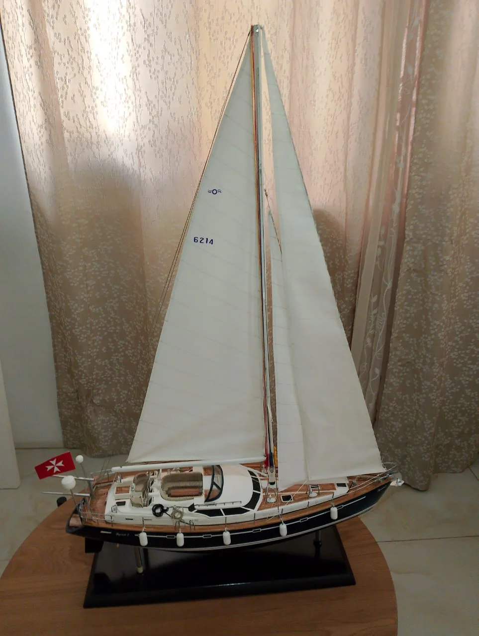 Handcrafted premium wooden scale model of the modern Delphia 29 sailing cruiser with full rigging on a luxury stand.